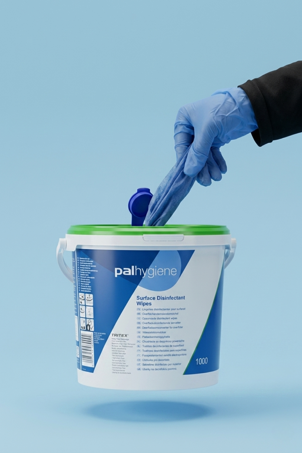 Hand wearing a blue glove taking out surface disinfectant wipes from a Palihygiene container on a light blue background