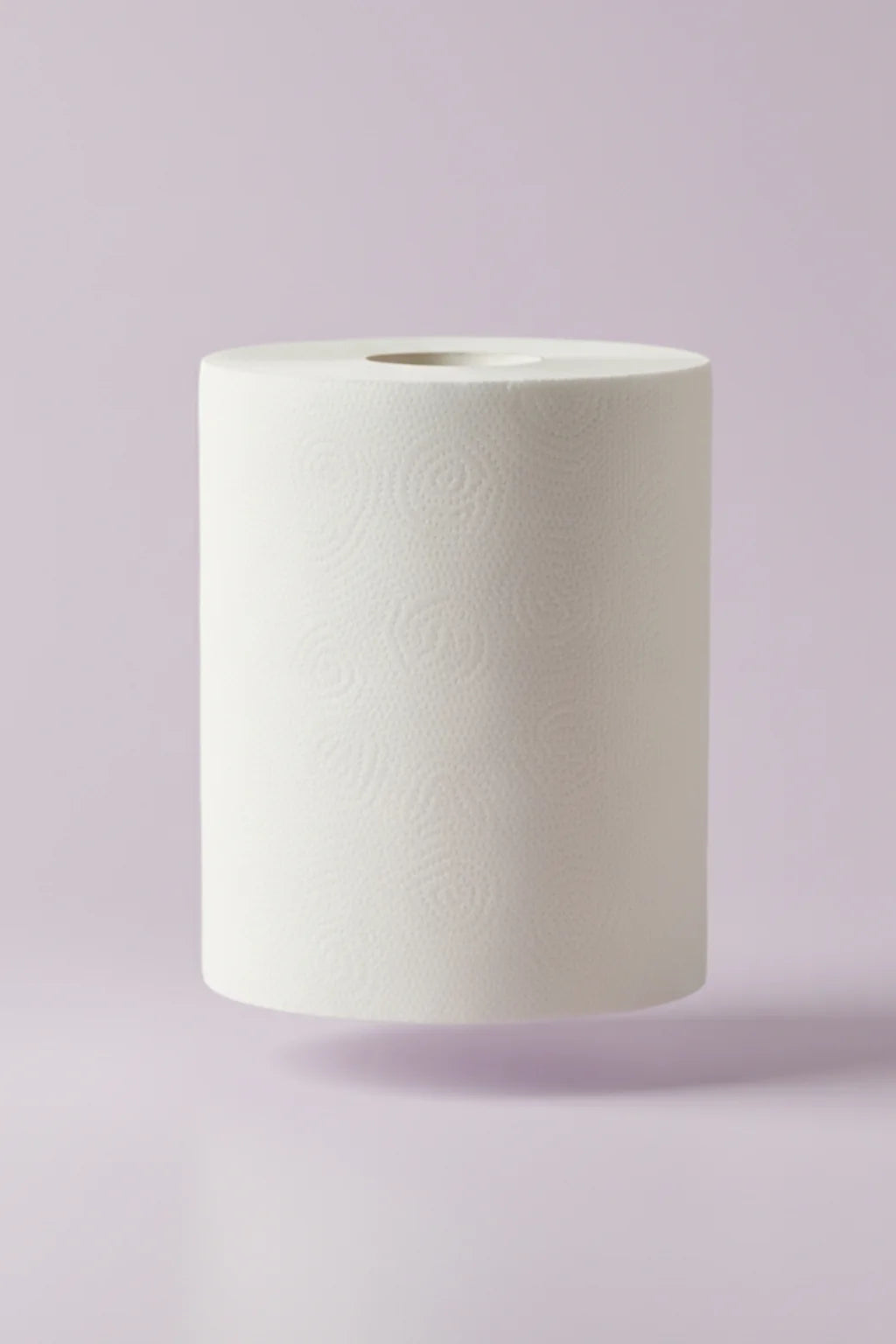White roll of maxi roll tissue paper on a light purple background