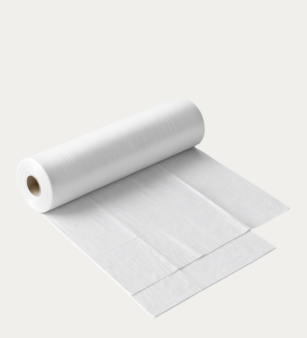 Roll of disposable table sheets (110×100 cm) showing clean, white pre-cut sheets, perfect for salons, clinics, and catering use in Qatar